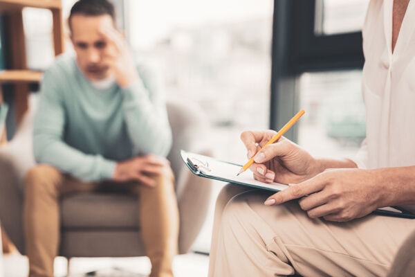 A compassionate psychiatrist, covered by Gilsbar mental health insurance, actively listens to her patient during a therapy session