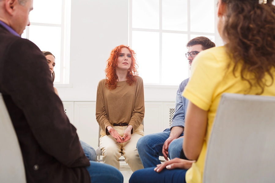 A small support group seated in a circle, people listening attentively to one another at our dependent personality disorder treatment center in Phoenix, AZ