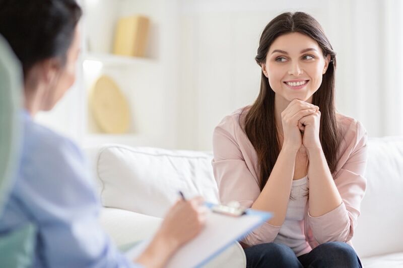 A smiling woman in a therapy session, illustrating how to help someone with cocaine addiction through counseling