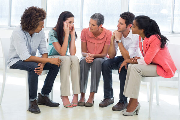 A group therapy session with five people sitting in a circle, supporting each other, highlighting meth treatment Phoenix, Arizona