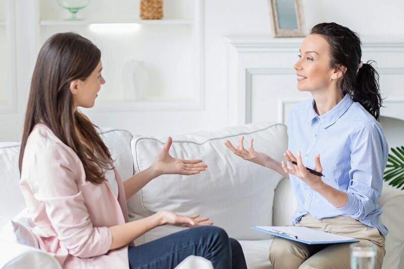 A woman speaks with a therapist, discussing possible behavioral changes related to substance abuse and dependency.