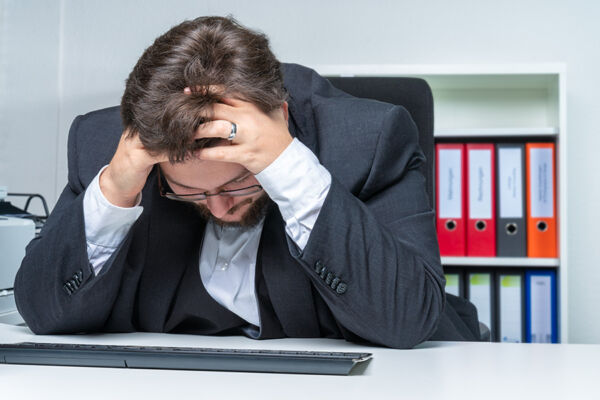  Distressed businessman with hands on his head, losing focus, symbolizing the struggle of medication addiction and the necessity of Rehabilitation centers for medication in Phoenix