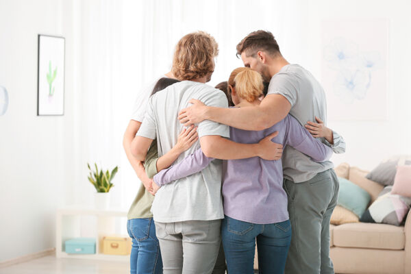 Family and friends hug symbolizing a successful drug intervention