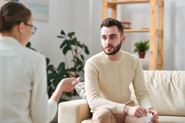 Focused man attentively listening to a therapist during a Dialectical Behavioral Therapy (DBT) session