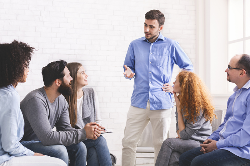 Group of diverse adults attentively listening to a speaker in a heroin rehab near Phoenix, AZ