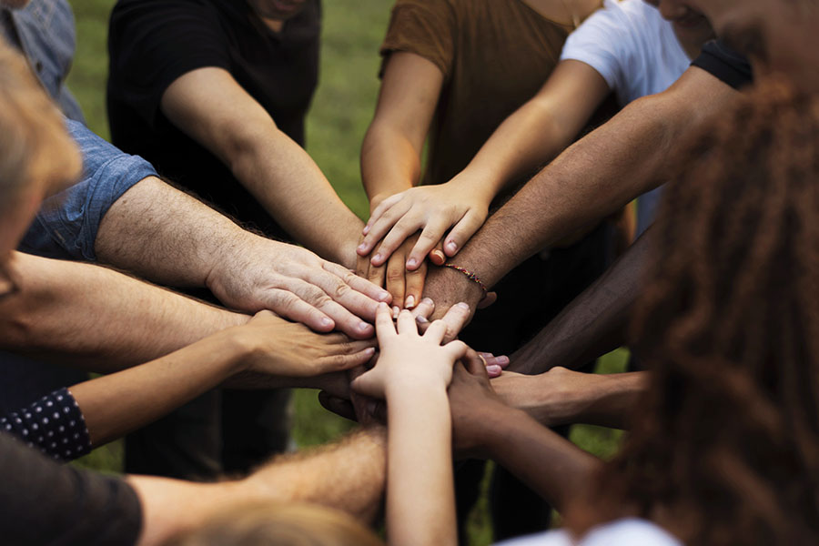 Group of patients at our 30-day inpatient drug rehab center in Arizona with their hands all in the middle of a circle