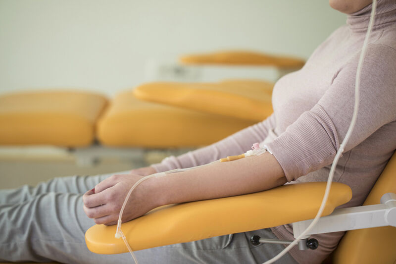 Patient receiving intravenous treatment while seated in a clinic, illustrating a ketamine therapy Phoenix for mental health