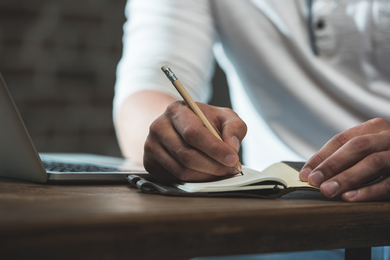 Person drafting a drug relapse prevention plan on a notepad