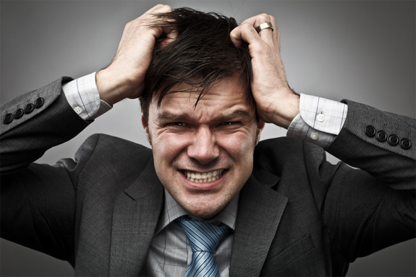 Stressed businessman gripping his hair, symbolizing battling heroin addiction.