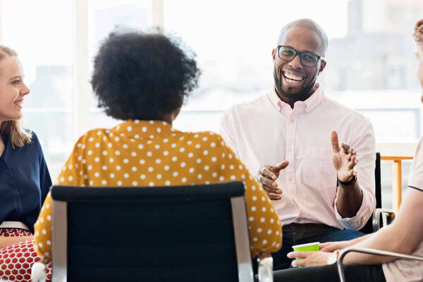 Young adult man speaking in a group showing dbt interpersonal effectiveness, a key aspect of overcoming challenges in interpersonal relationships.