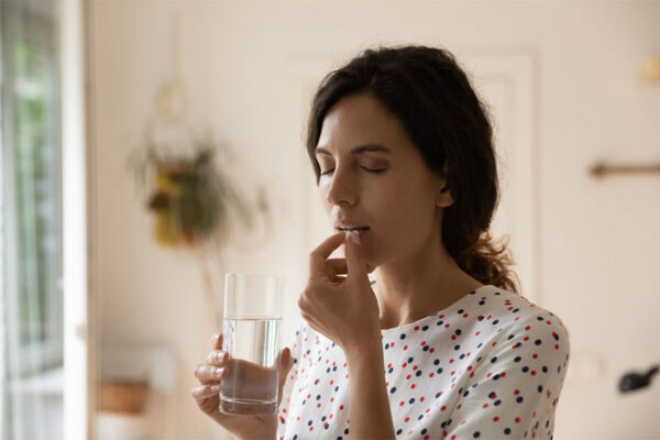 Young woman taking her prescribed medication for mental health treatment